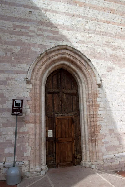 De toegangsklep van de kant van de kerk in assisi — Stockfoto