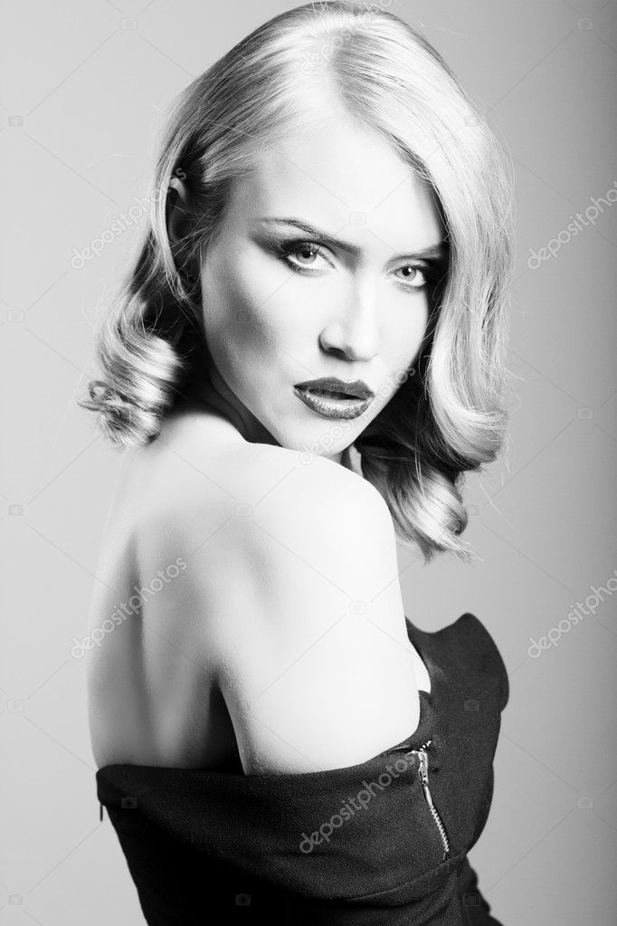 Blonde woman with glamorous hairstuly and make up looking tense