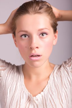 Portrait of attractive young woman looking shocked isolated on w