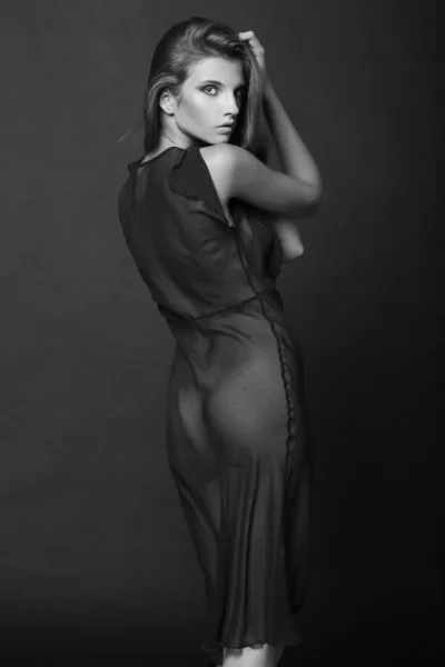 Elegant kvinna med långt hår i natt klä på mörk bakgrund — Stockfoto
