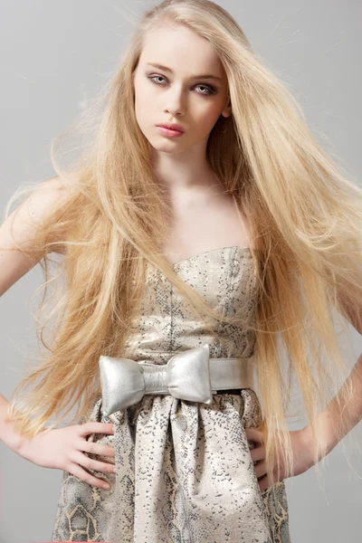 Молодая женщина с длинными светлыми волосами в модном платье — стоковое фото