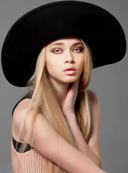 Fashion teen model in a black big hat in studio — Stock Photo, Image
