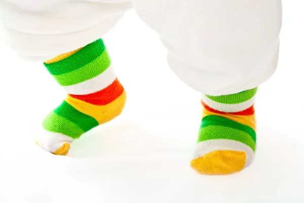 Patas de bebé en calcetines de rayas deportivas . —  Fotos de Stock