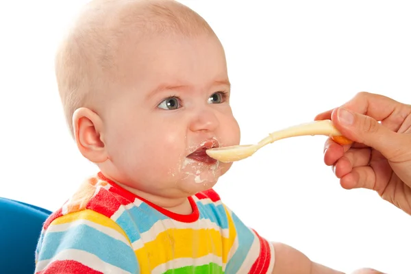 Pequeño bebé está alimentando cuajada de cuchara —  Fotos de Stock