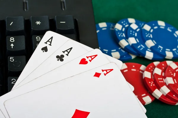 stock image Fragment of black keyboard with gamble chips and cards.