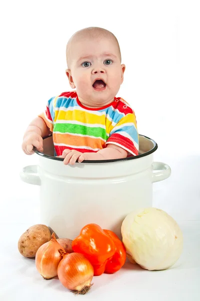 Bebê sentado na panela grande com legumes . — Fotografia de Stock