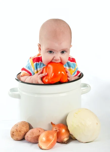 宝宝坐在用蔬菜大把锅. — 图库照片