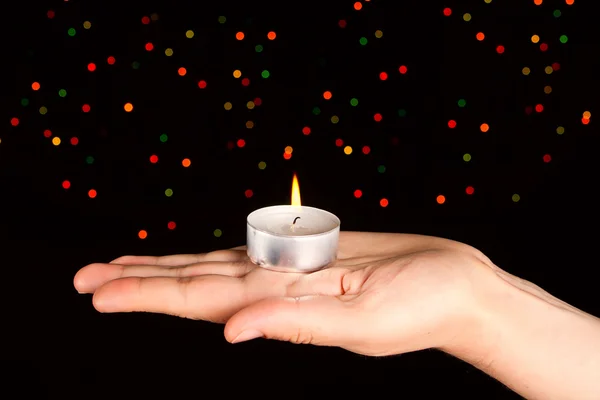 Candle with many-colored sparkles on hand. — Stock Photo, Image