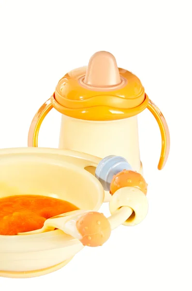 Children plate with pumpkin porridge and baby bottle. — Stock Photo, Image