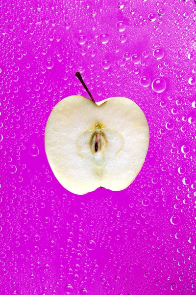 Apfelsegment auf rosa Hintergrund mit Wassertropfen — Stockfoto