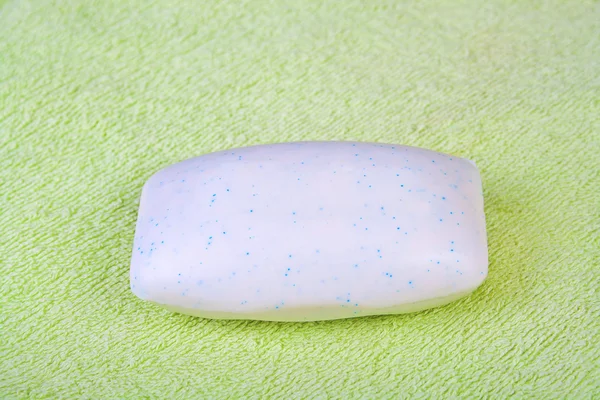 Soap bar on green bath-towel. — Stock Photo, Image