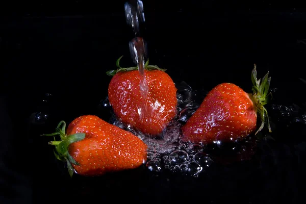 Aardbeien in stromend water. — Stockfoto