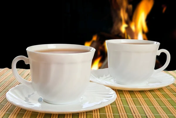 Due tazze da tè su sfondo fuoco . — Foto Stock