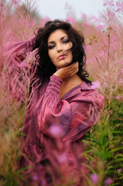 Романтическая женщина среди розовых цветов — стоковое фото