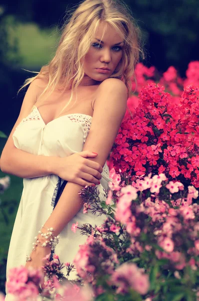 Çiçekler arasında duran kadın — Stok fotoğraf