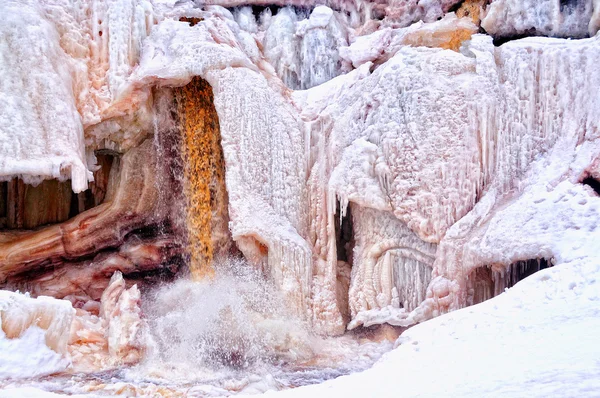 Water trapsgewijs uit een bevroren waterval — Stockfoto