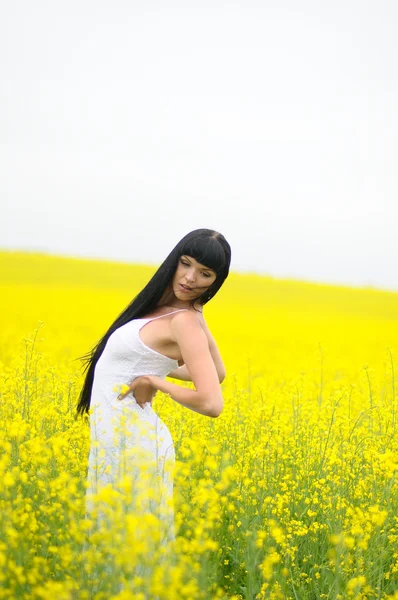 Szép nő, sárga káposztarepce terén — Stock Fotó