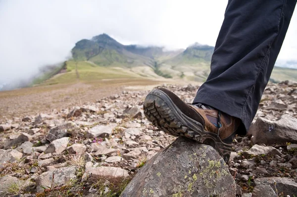 Tourist in hiking shoes atop the mountain — Stock Photo, Image