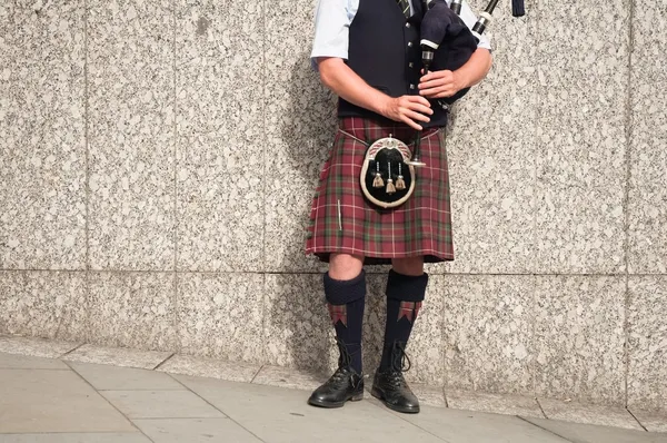 Gaitero vestido con falda escocesa jugando a las pipas de bolsa —  Fotos de Stock