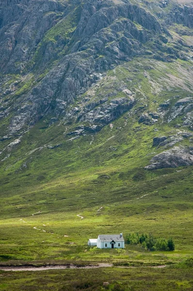 Μικρό σπίτι κάτω από τεράστια βουνά — Φωτογραφία Αρχείου