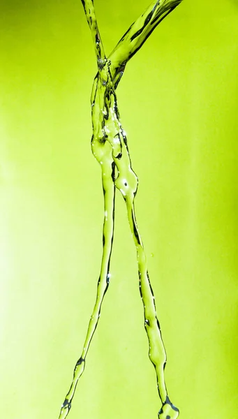 Water splash against green background — Stock Photo, Image