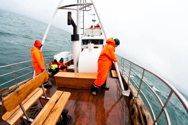 Noszenie pomarańczowy płaszcz na połów łódka — Zdjęcie stockowe