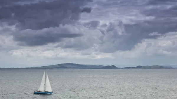 Yacht sailing under heavy clouds — Stock Photo, Image