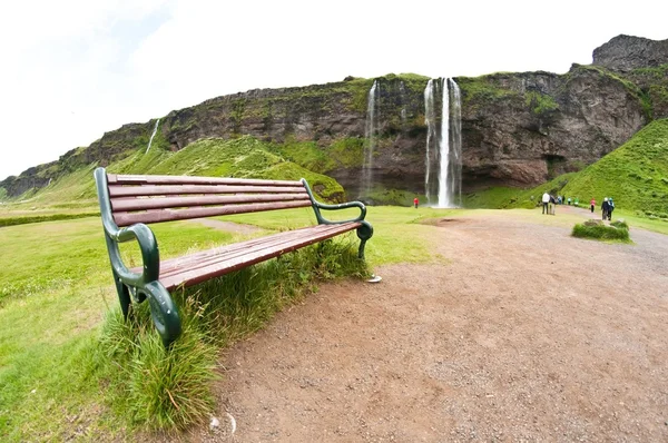 Лавка для відпочинку біля водоспаду — стокове фото