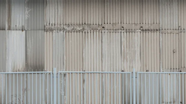 Oude metalen gebouw achter het hek — Stockfoto
