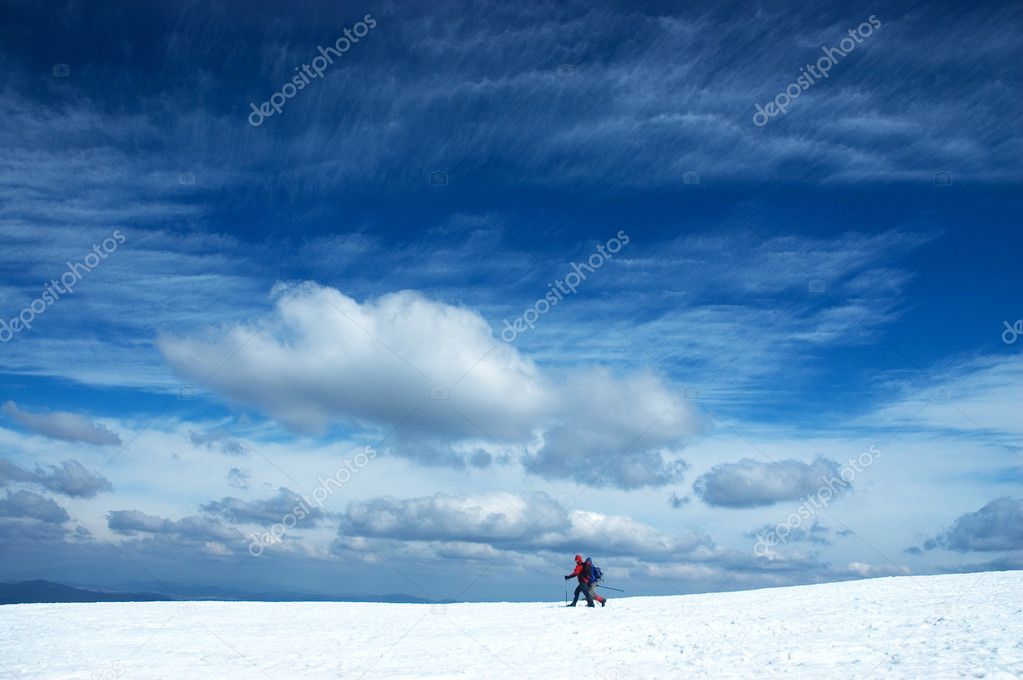 Two alpine skiers under dramatic sky