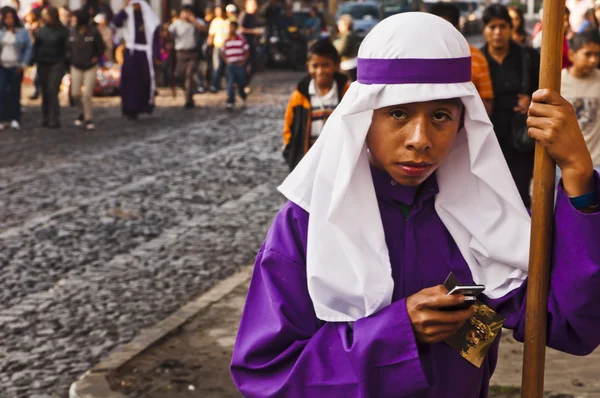 Пурпурный мальчик в мантии по мобильному телефону Стоковая Картинка