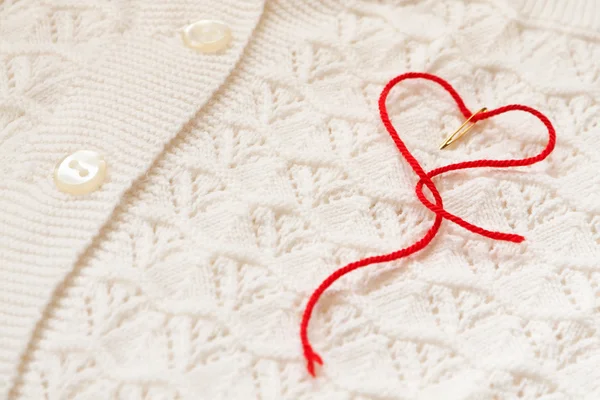 Красное сердце на белую блузку — стоковое фото