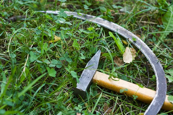 镰刀和锤子在草地上 — 图库照片