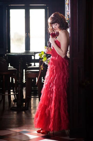 Жінка в червоному з трояндою — стокове фото