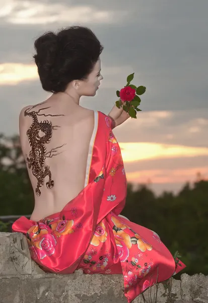 Gueixa com tatuagem de dragão ao pôr do sol — Fotografia de Stock