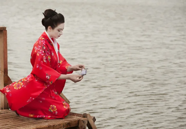 Geisha lanceert origami vogel — Stockfoto