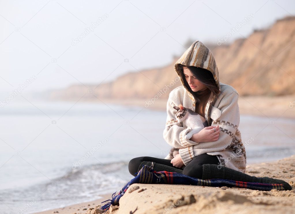 Girl with her cat against a sea