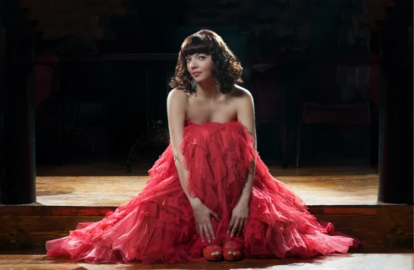 赤いイブニング ドレスで座りをする女性 — ストック写真