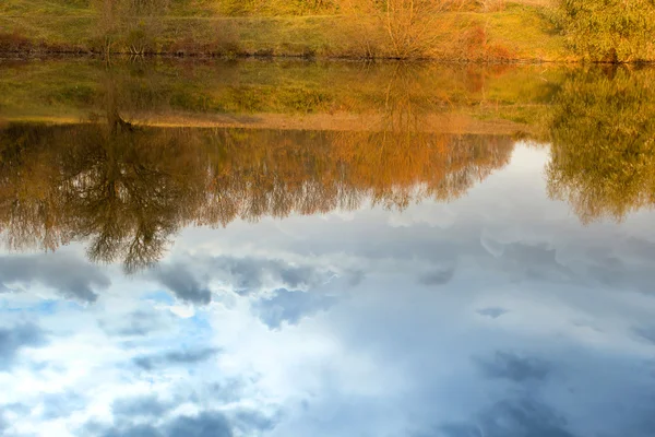 Reflexão do céu e árvores na água no outono — Fotografia de Stock