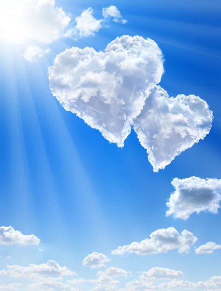 Srdce v oblacích proti modré obloze čisté — Stock fotografie