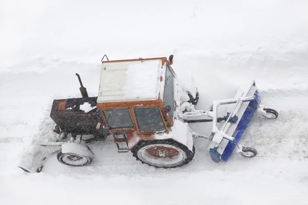 stock image Tractor cleans the street in heavy snow