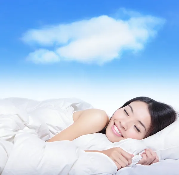Ung flicka sova på en kudde med vita moln — Stockfoto
