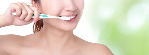 Mujer cepillándose los dientes con fondo verde — Foto de Stock