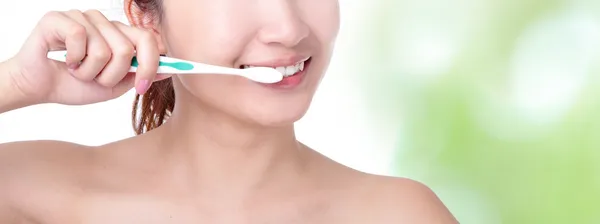 Mujer cepillándose los dientes con fondo verde —  Fotos de Stock