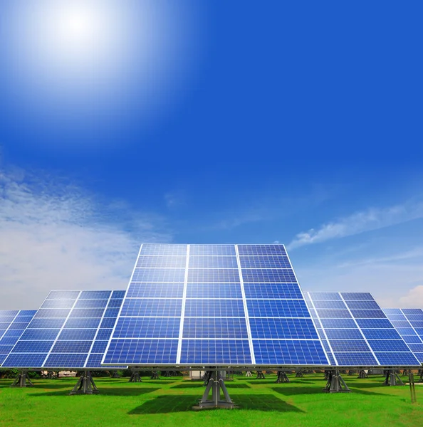Painel solar com grama verde e céu azul bonito — Fotografia de Stock