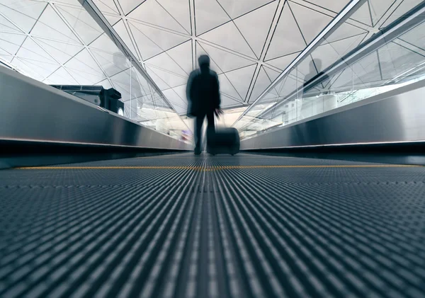 Pasajero (Hombre) corriendo a través de una escalera mecánica en la terminal del aeropuerto — Foto de Stock