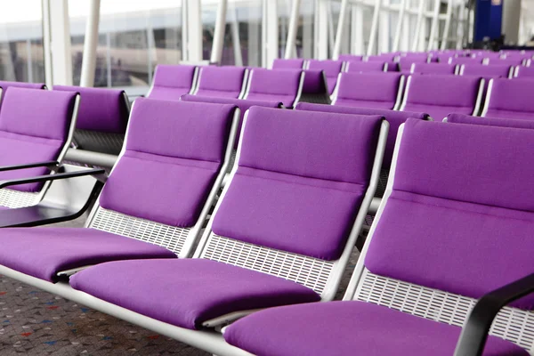 Stuhlreihe lila am Flughafen — Stockfoto