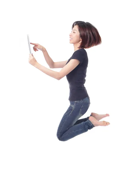 Jonge schoonheid gelukkig sprong en tablet pc gebruikt in de lucht — Stockfoto