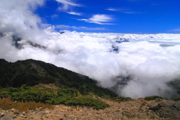 Haute montagne avec mer de nuages et ciel bleu — Photo