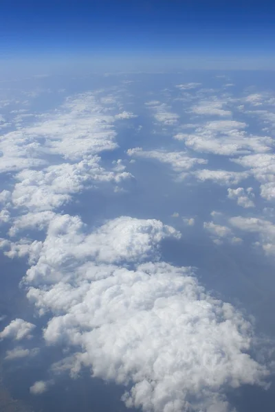 Mavi gökyüzünde bulutlar görünümünden uçak uçak güneşli bir gün — Stok fotoğraf